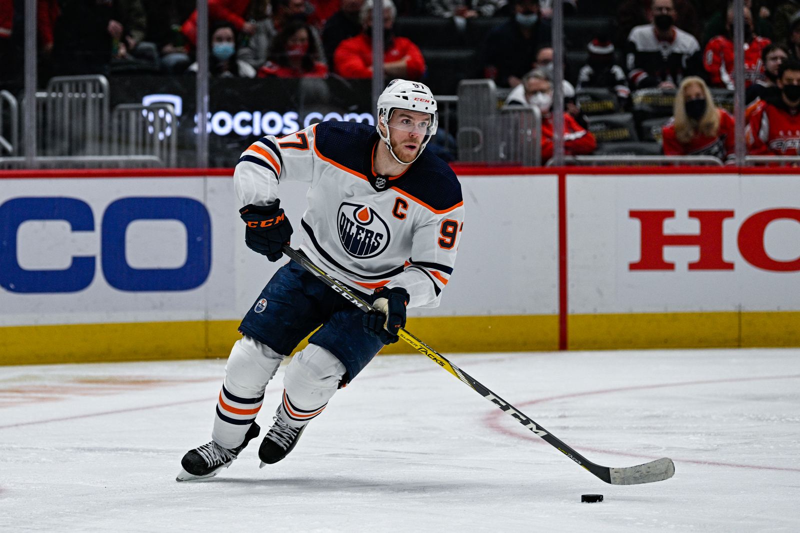Connor McDavid carrying the puck at full stride in an Edmonton Oilers away jersey, Capital One Arena, February 2022.
